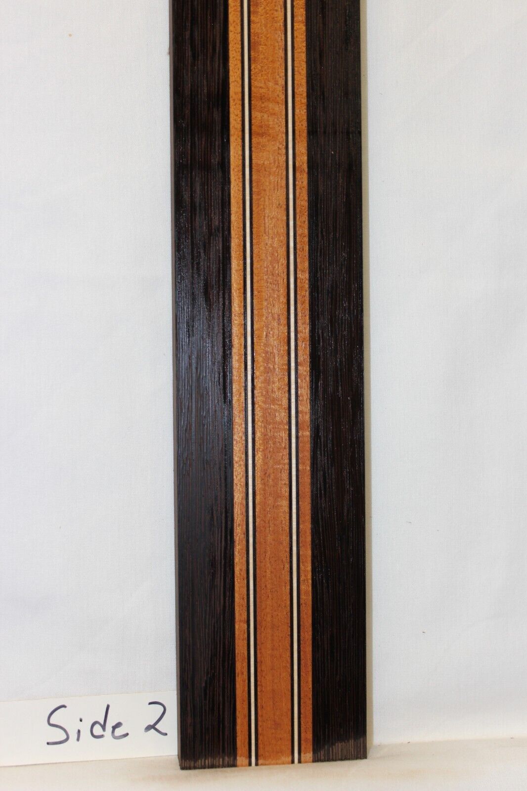 Figured mahogany, wenge and hard maple laminated guitar neck blank.