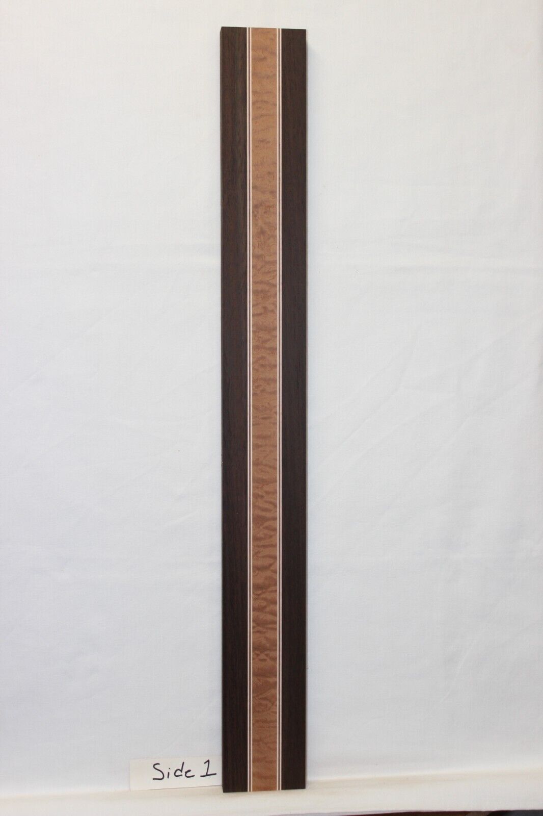 Quilted sapele, wenge, hard maple and purple-heart laminated guitar neck blank.