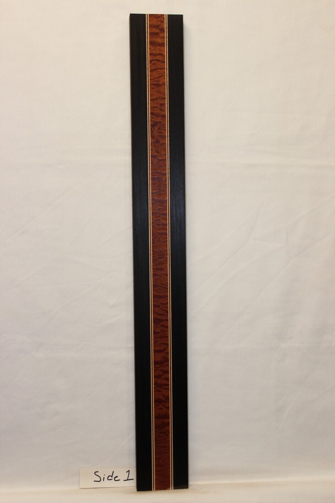 Quilted sapele, wenge, hard maple and purple-heart laminated guitar neck blank.