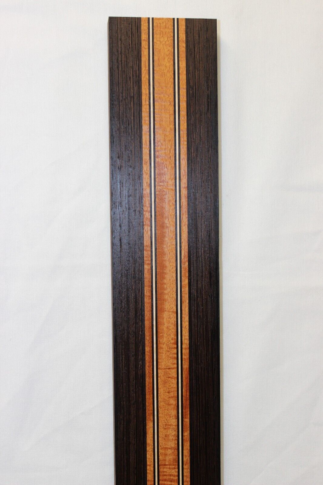 Figured mahogany, wenge and hard maple laminated guitar neck blank.