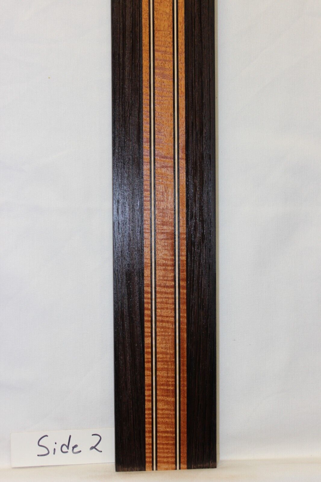Figured mahogany, wenge and hard maple laminated guitar neck blank.