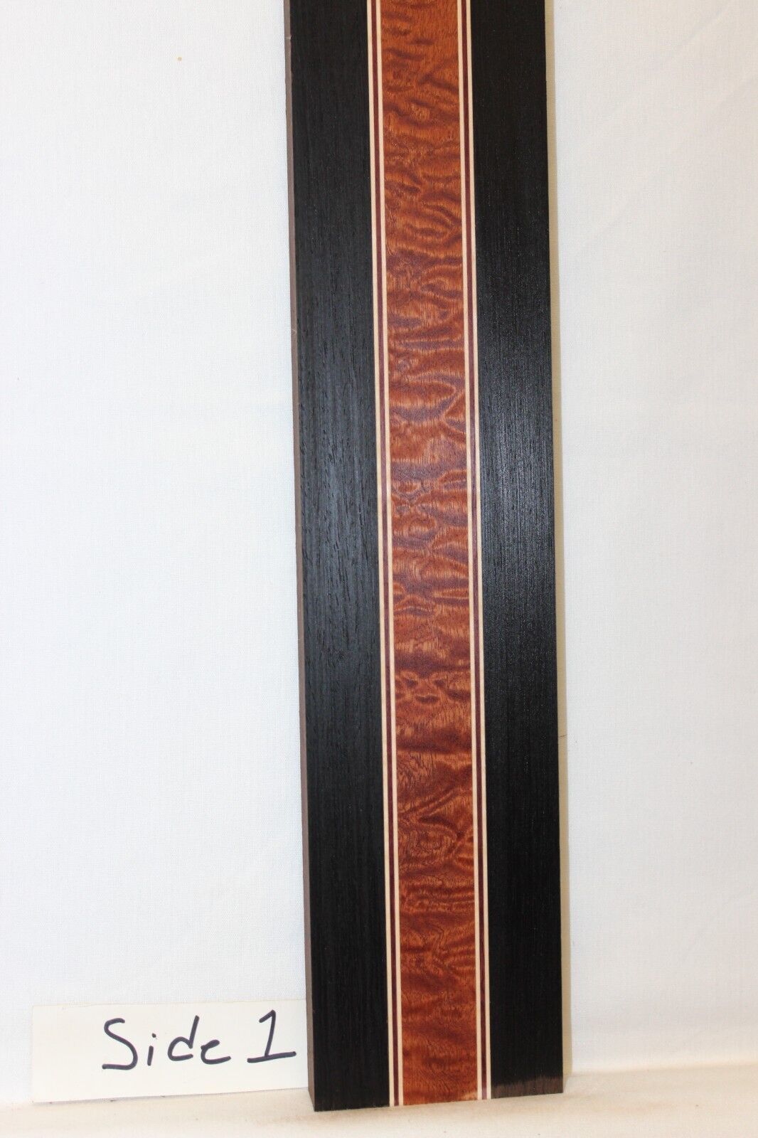 Quilted sapele, wenge, hard maple and purple-heart laminated guitar neck blank.
