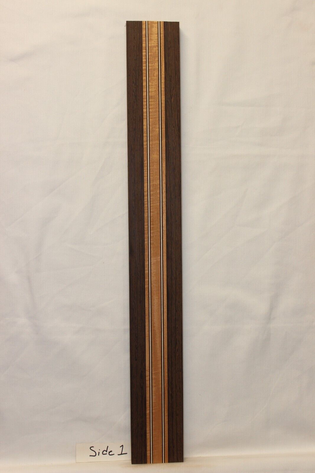 Figured mahogany, wenge and hard maple laminated guitar neck blank.