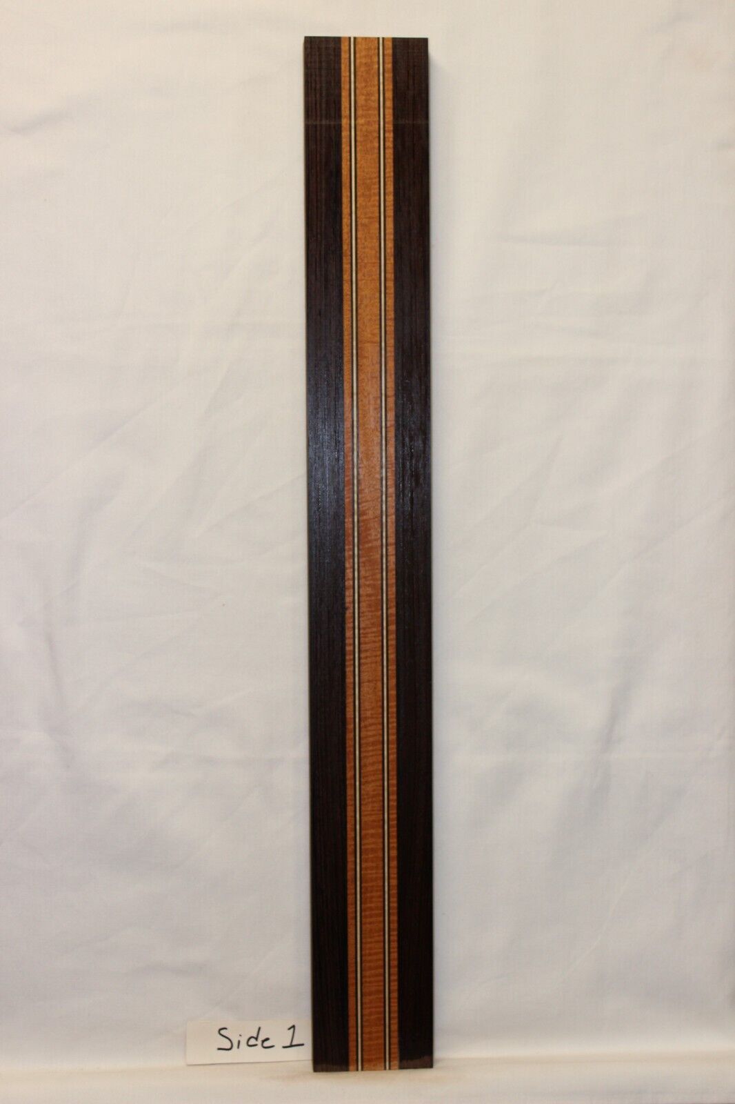 Figured mahogany, wenge and hard maple laminated guitar neck blank.