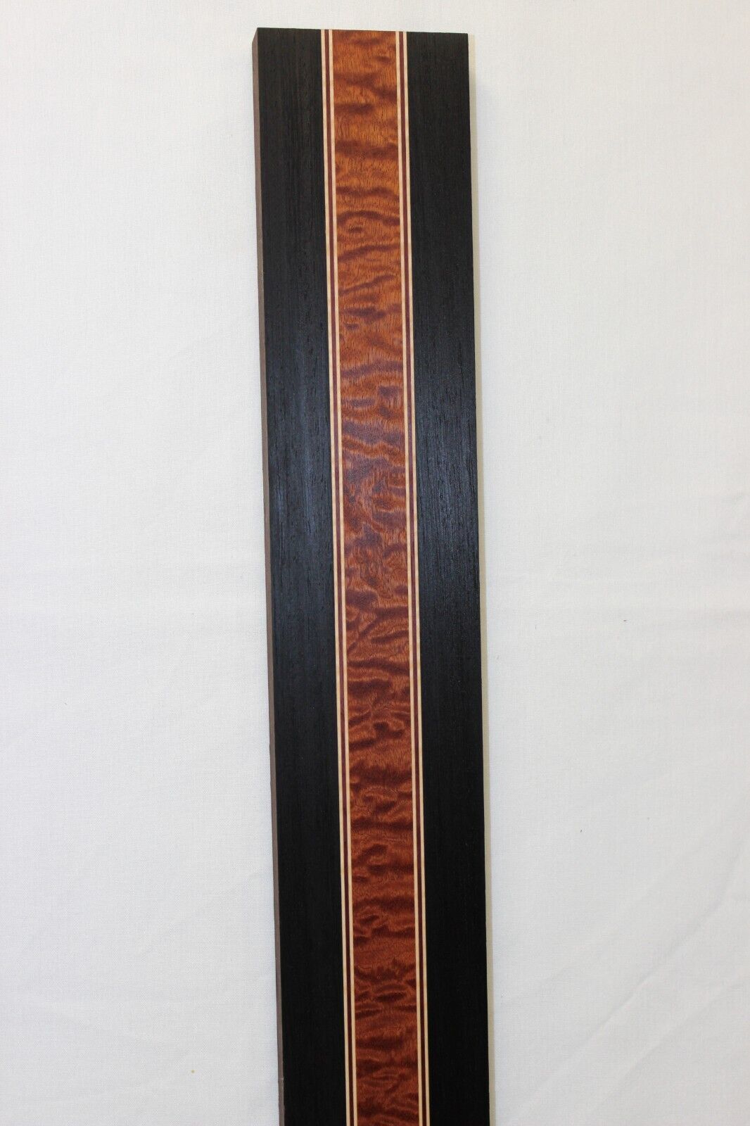 Quilted sapele, wenge, hard maple and purple-heart laminated guitar neck blank.