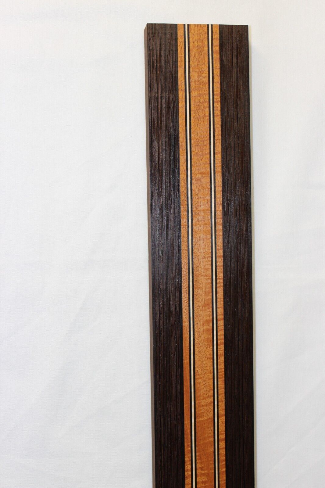 Figured mahogany, wenge and hard maple laminated guitar neck blank.