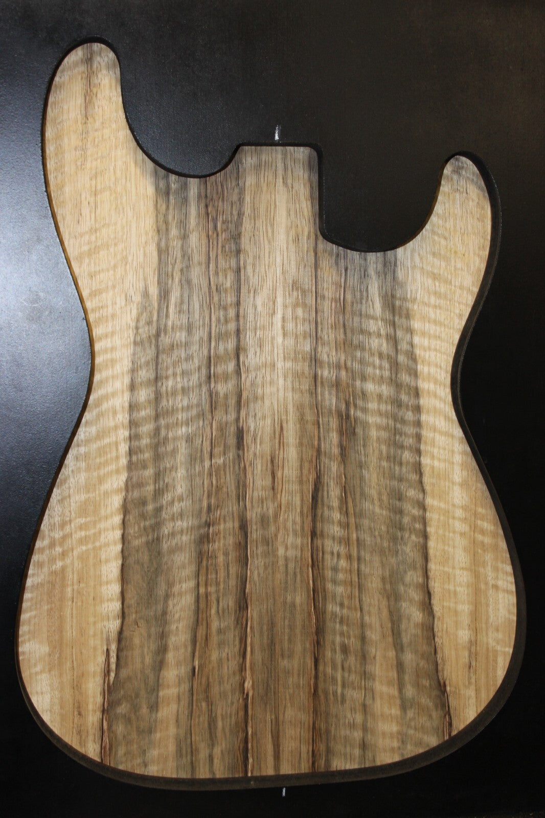 Curly black limba / korina figured book matched guitar top.