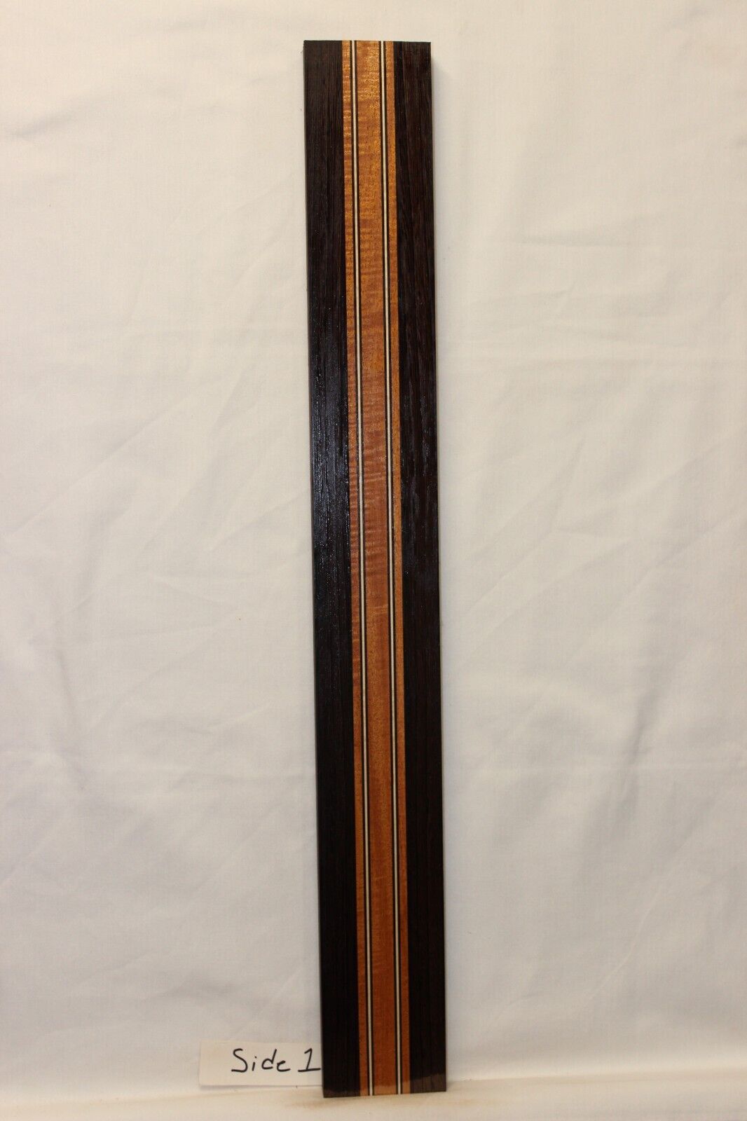 Figured mahogany, wenge and hard maple laminated guitar neck blank.