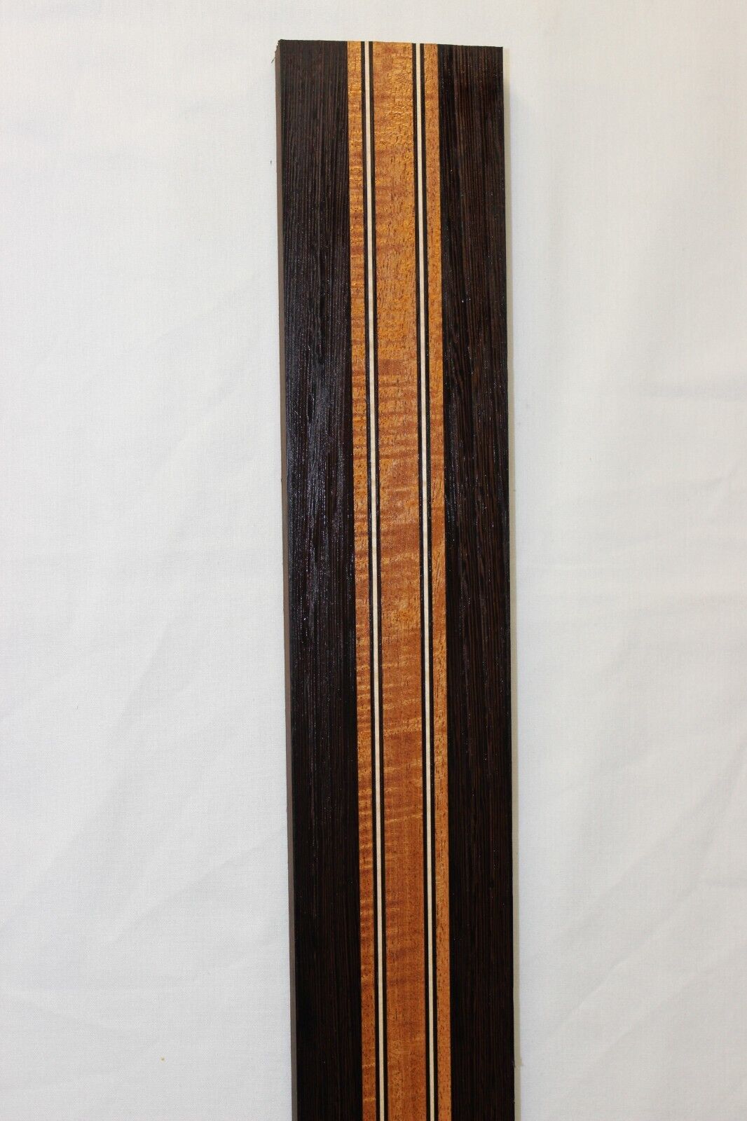 Figured mahogany, wenge and hard maple laminated guitar neck blank.