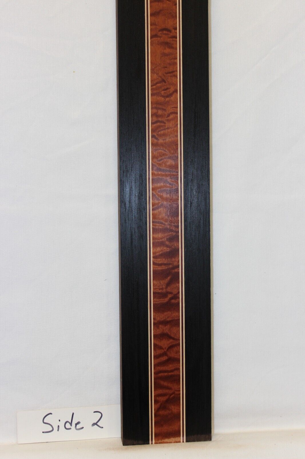 Quilted sapele, wenge, hard maple and purple-heart laminated guitar neck blank.