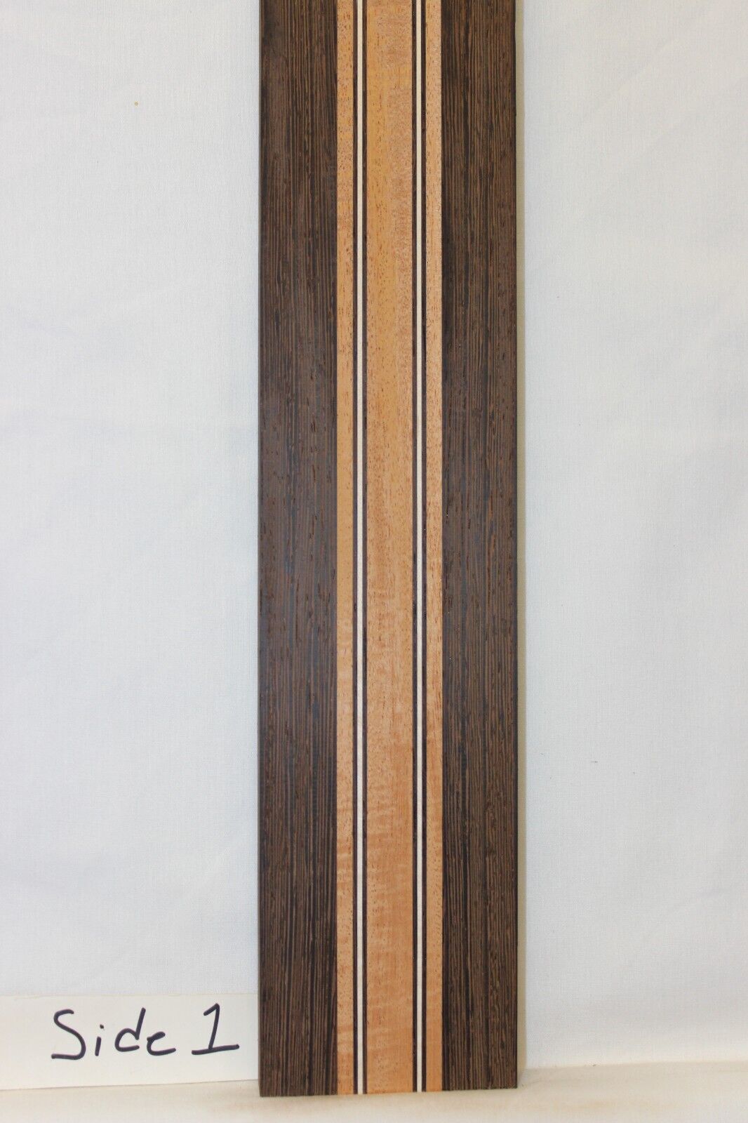Figured mahogany, wenge and hard maple laminated guitar neck blank.