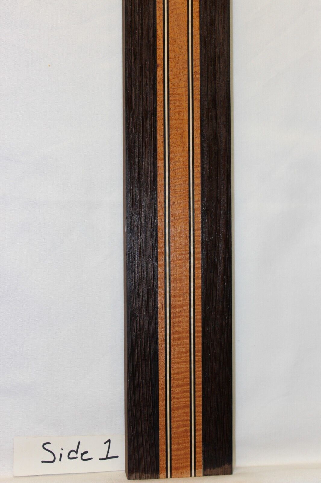 Figured mahogany, wenge and hard maple laminated guitar neck blank.