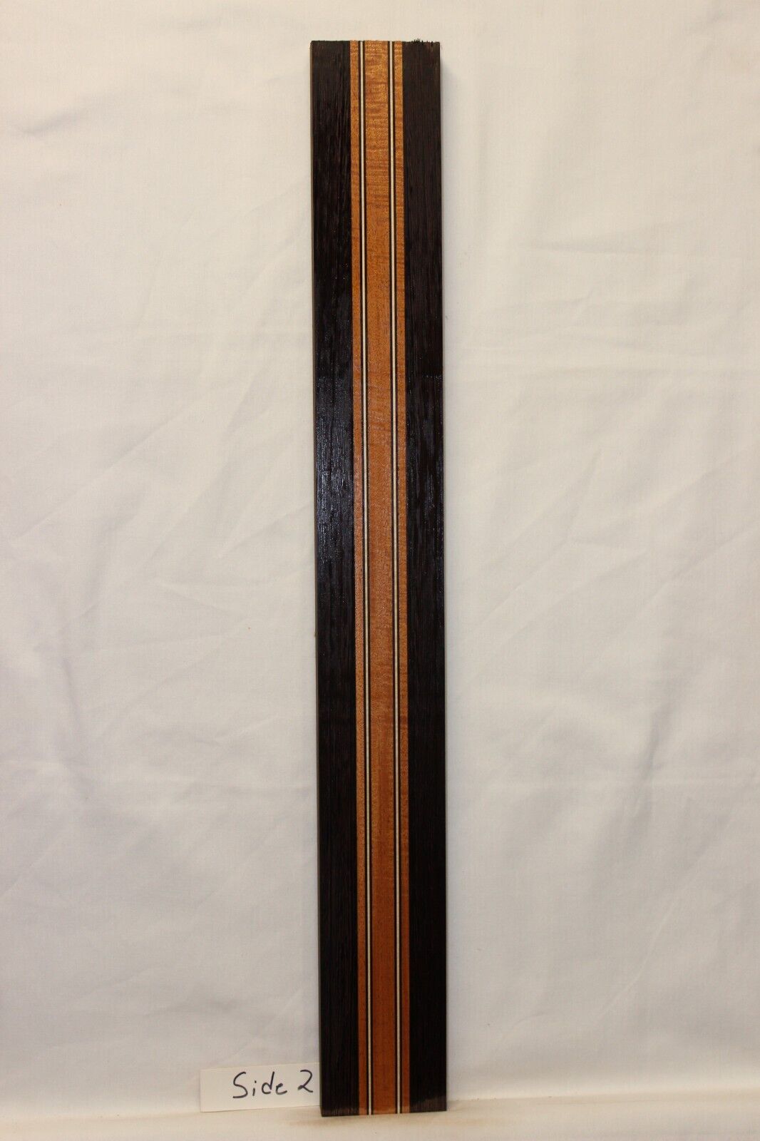 Figured mahogany, wenge and hard maple laminated guitar neck blank.