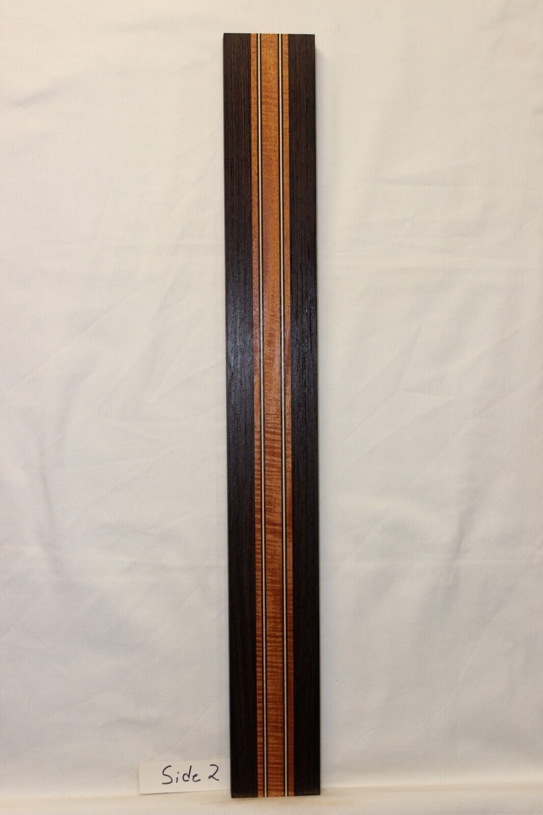 Figured mahogany, wenge and hard maple laminated guitar neck blank.
