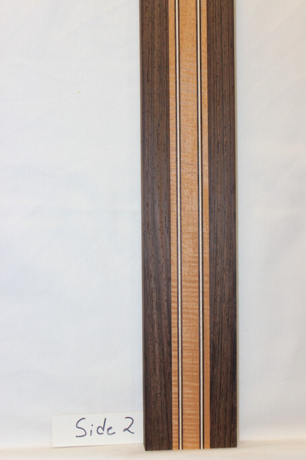 Figured mahogany, wenge and hard maple laminated guitar neck blank.