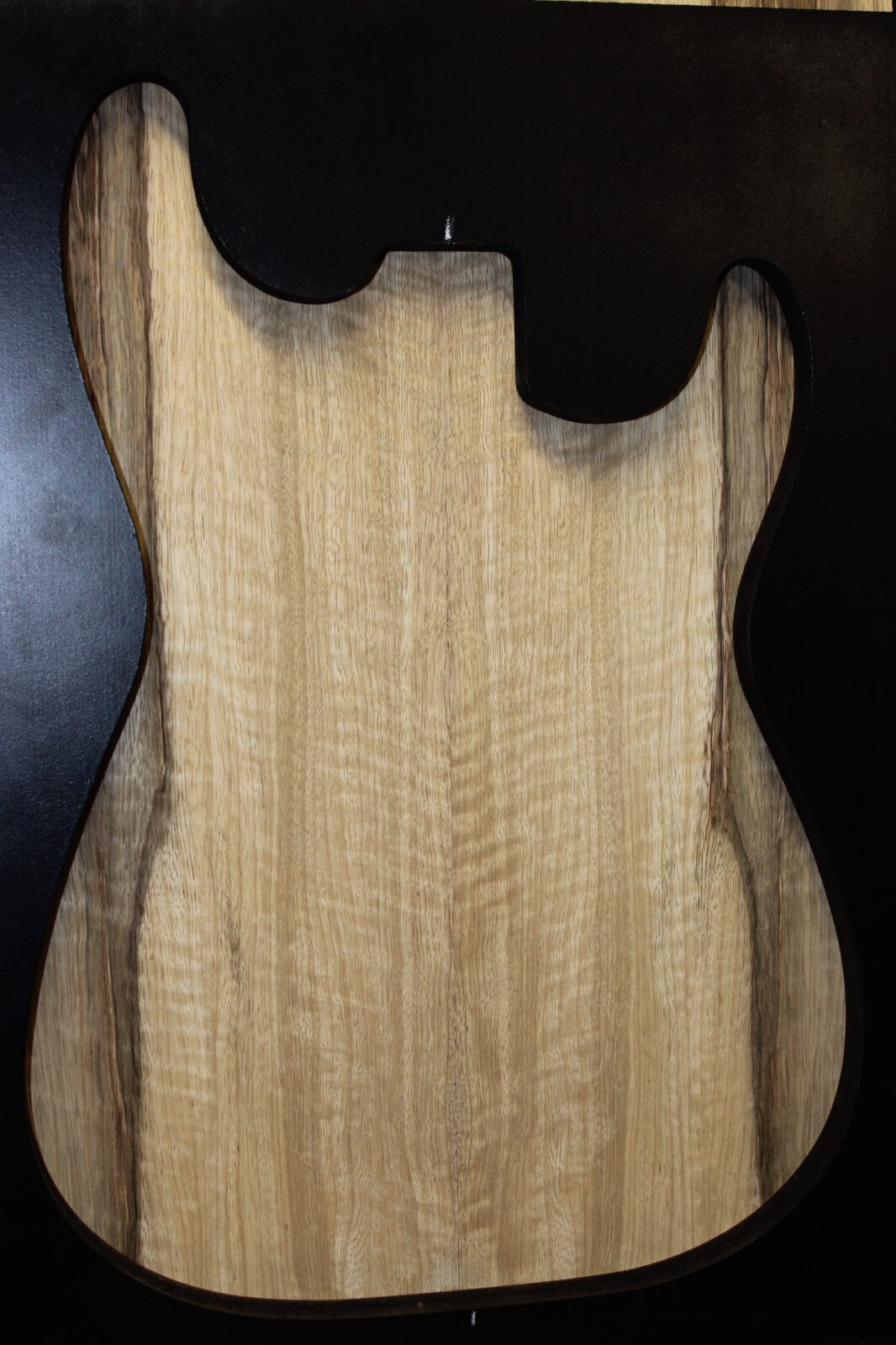 Curly black limba / korina figured book matched guitar top.