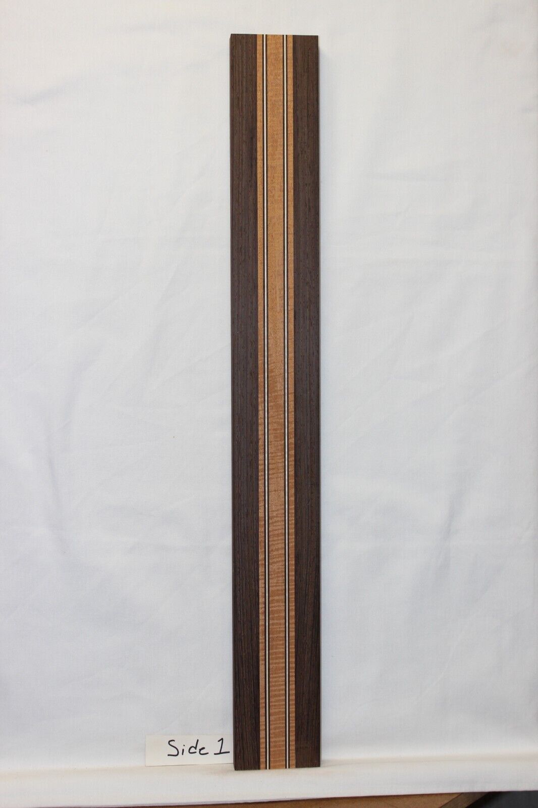 Figured mahogany, wenge and hard maple laminated guitar neck blank.