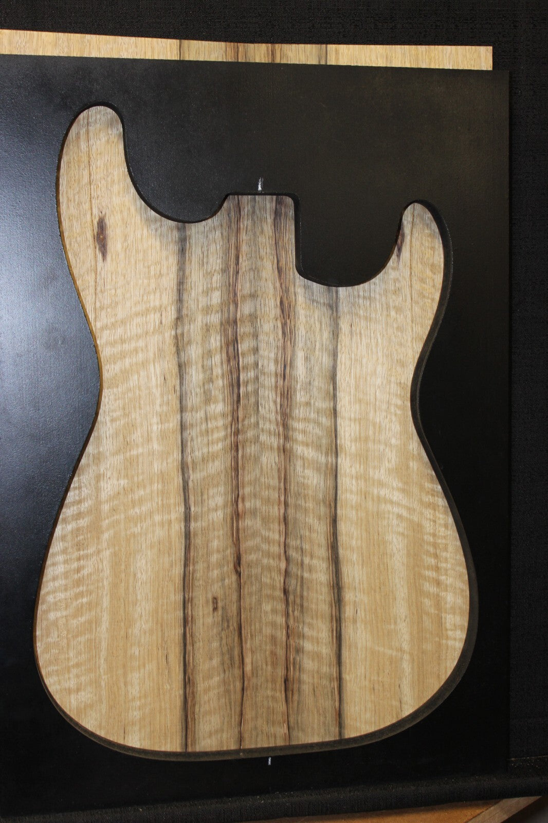 Curly black limba / korina figured book matched guitar top.