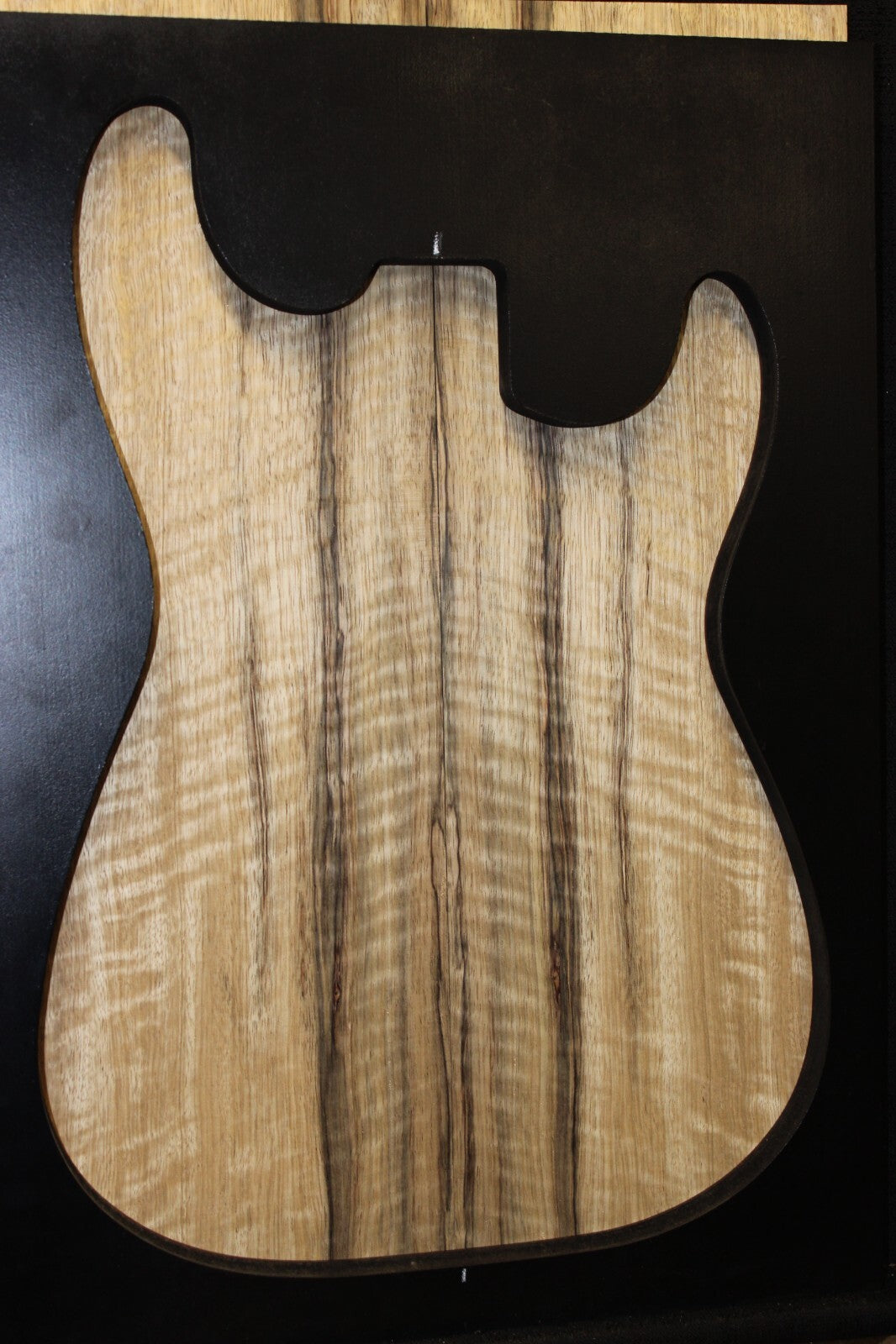 Curly black limba / korina figured book matched guitar top.