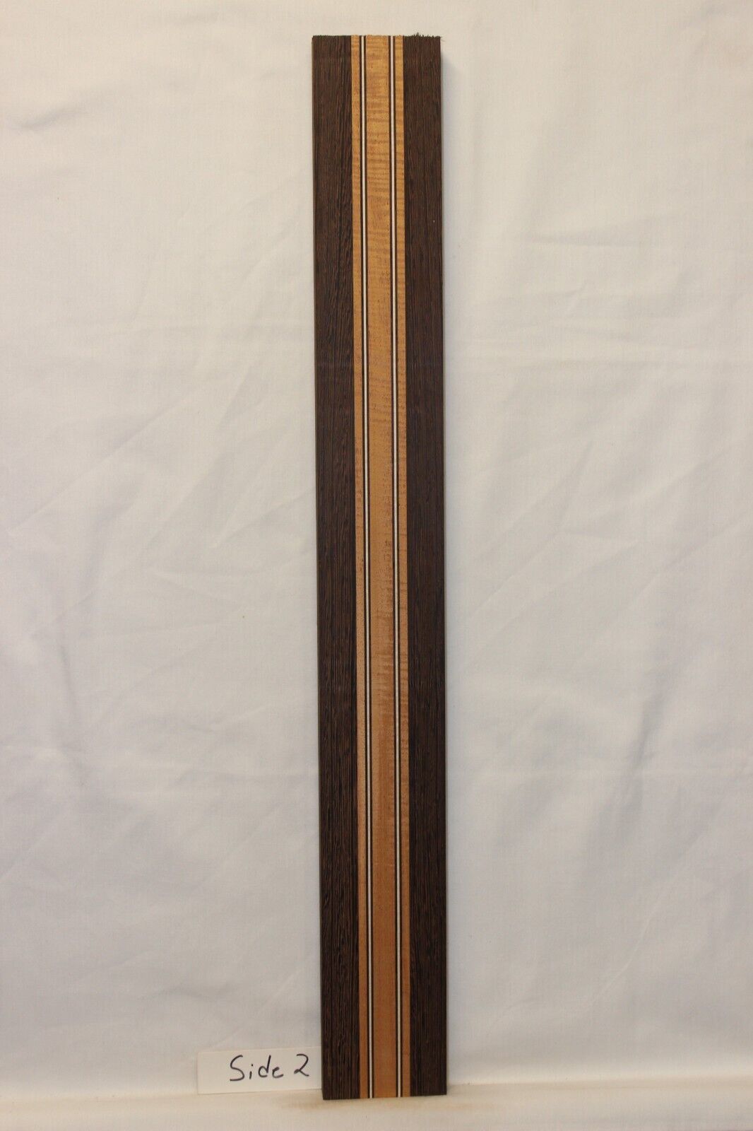Figured mahogany, wenge and hard maple laminated guitar neck blank.