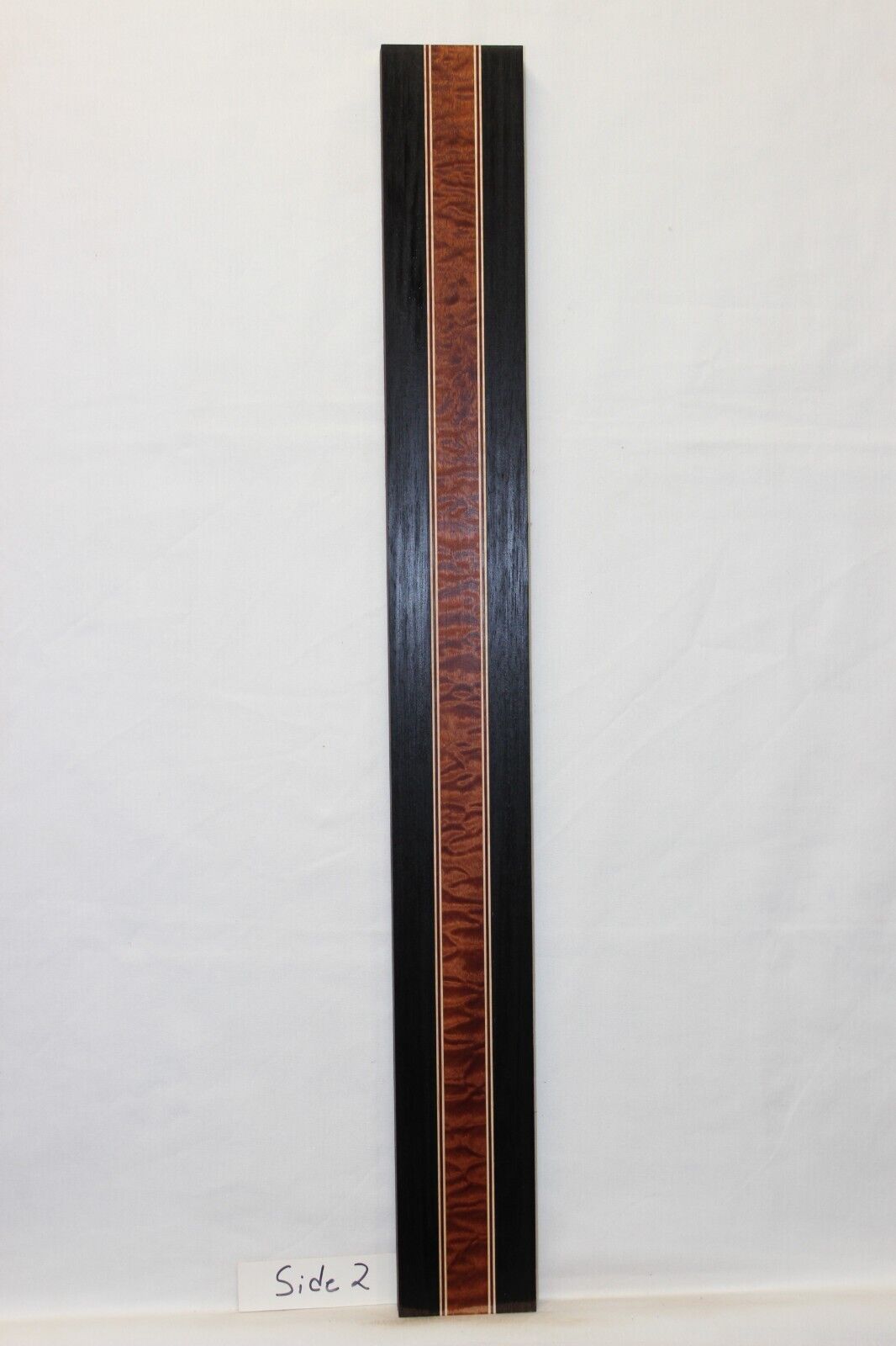 Quilted sapele, wenge, hard maple and purple-heart laminated guitar neck blank.