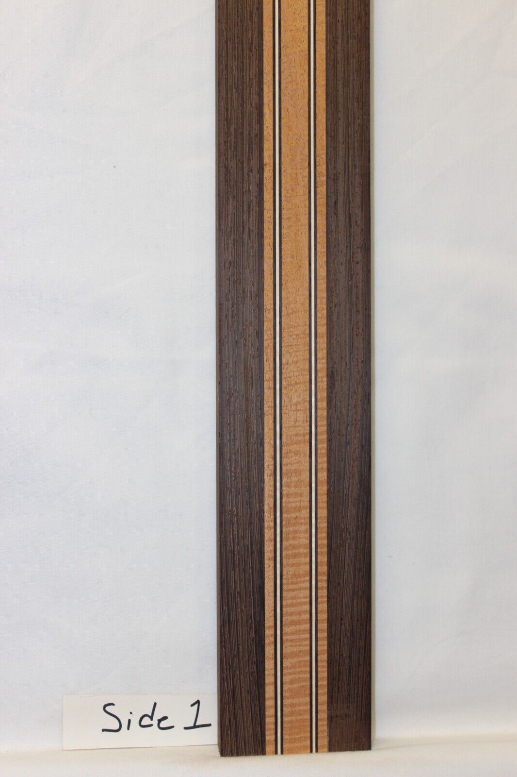 Figured mahogany, wenge and hard maple laminated guitar neck blank.