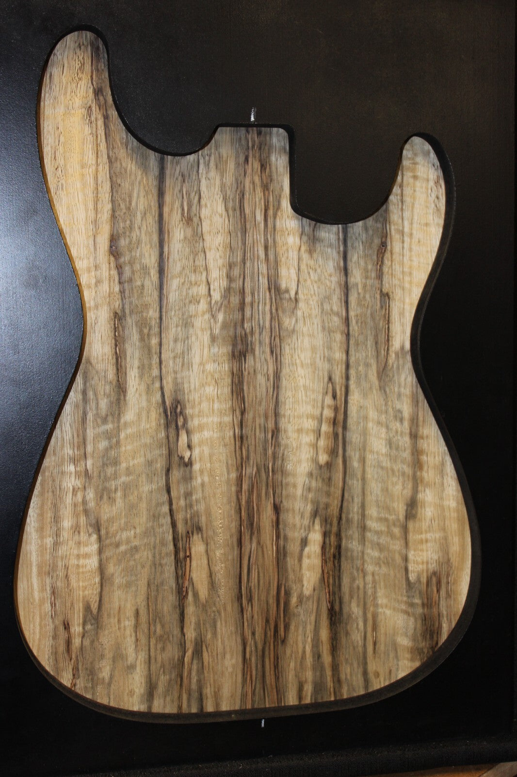 Curly black limba / korina figured book matched guitar top.