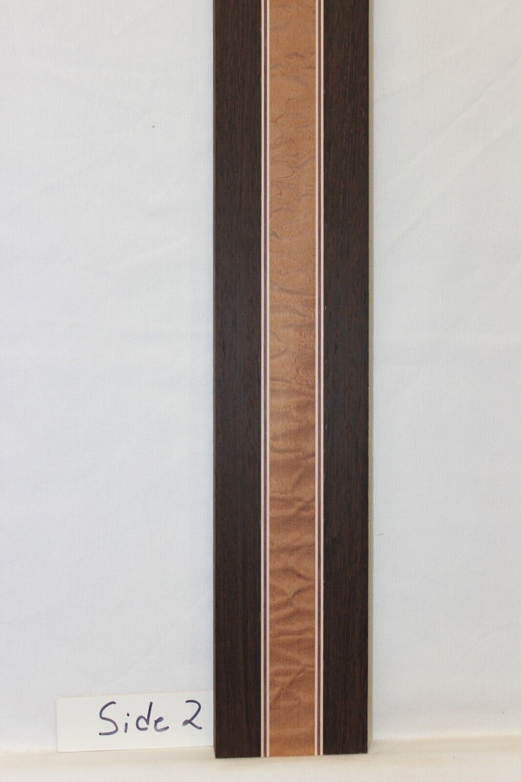 Quilted sapele, wenge, hard maple and purple-heart laminated guitar neck blank.