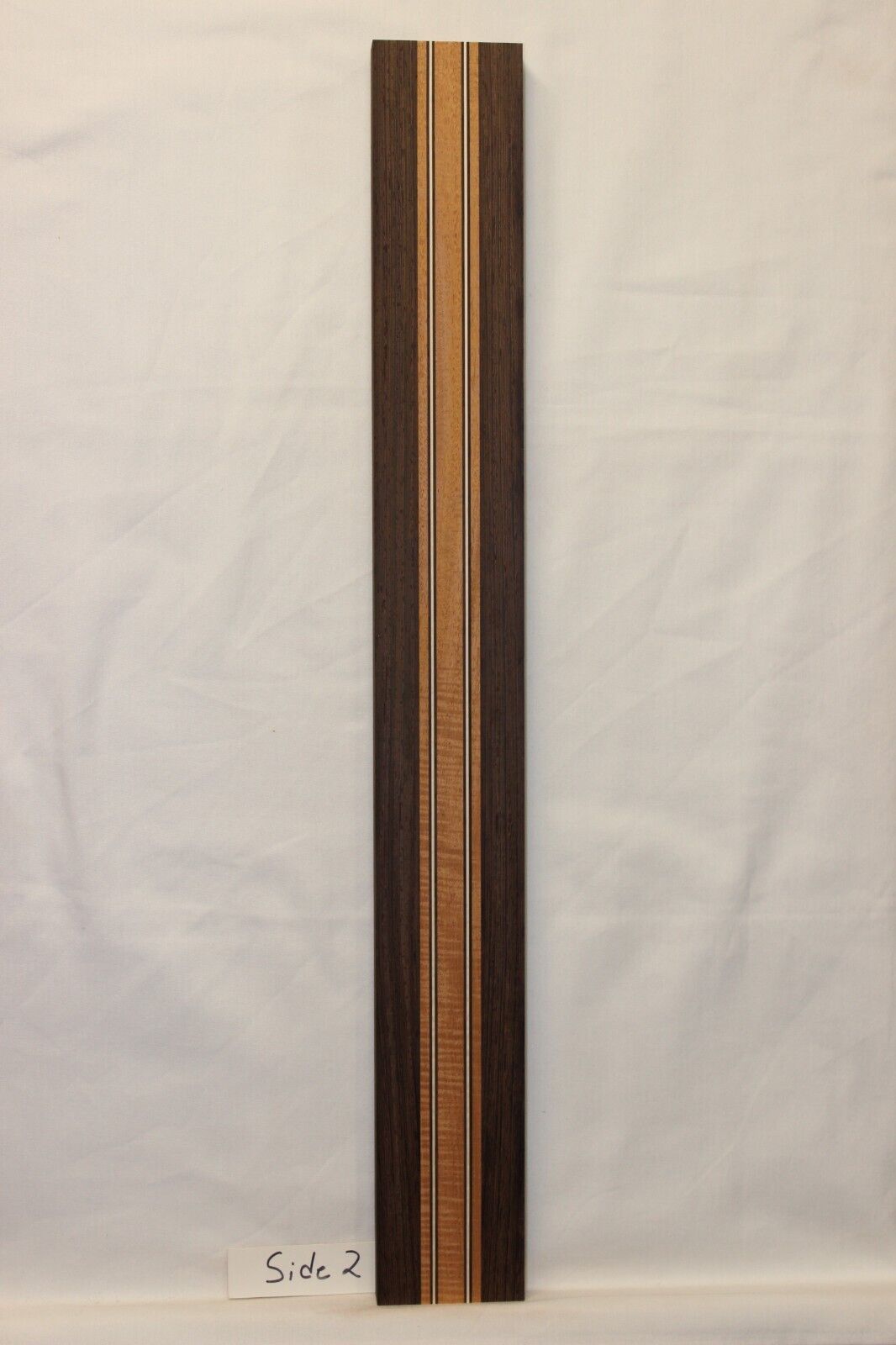 Figured mahogany, wenge and hard maple laminated guitar neck blank.
