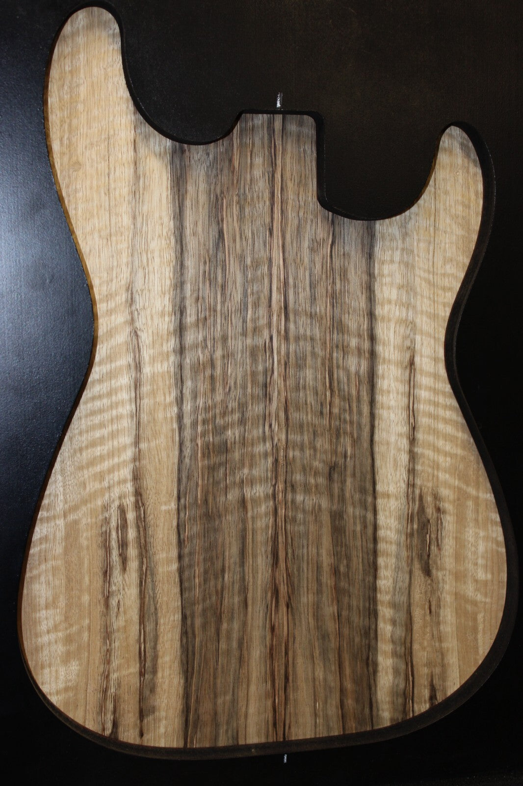 Curly black limba / korina figured book matched guitar top.