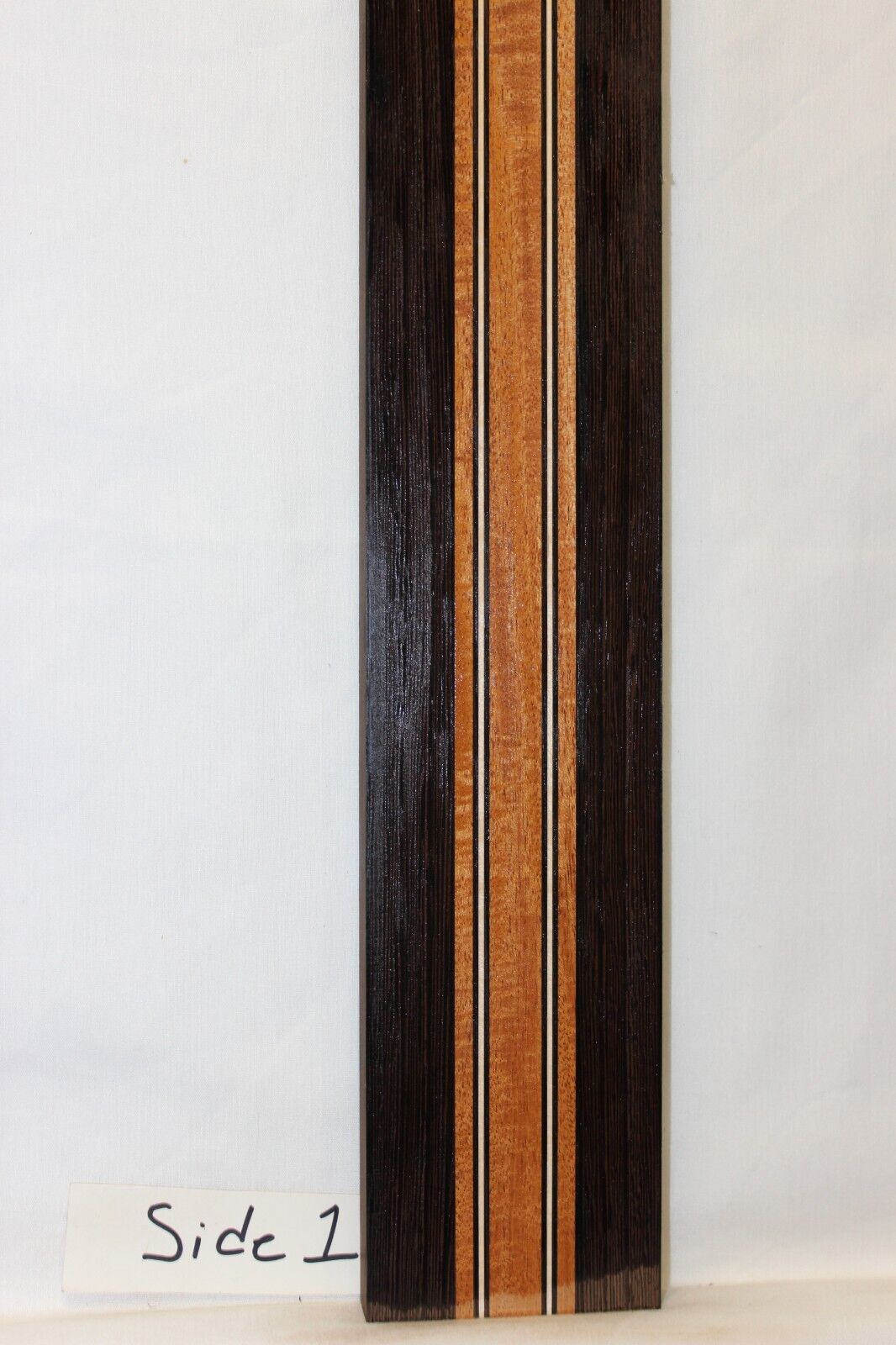 Figured mahogany, wenge and hard maple laminated guitar neck blank.