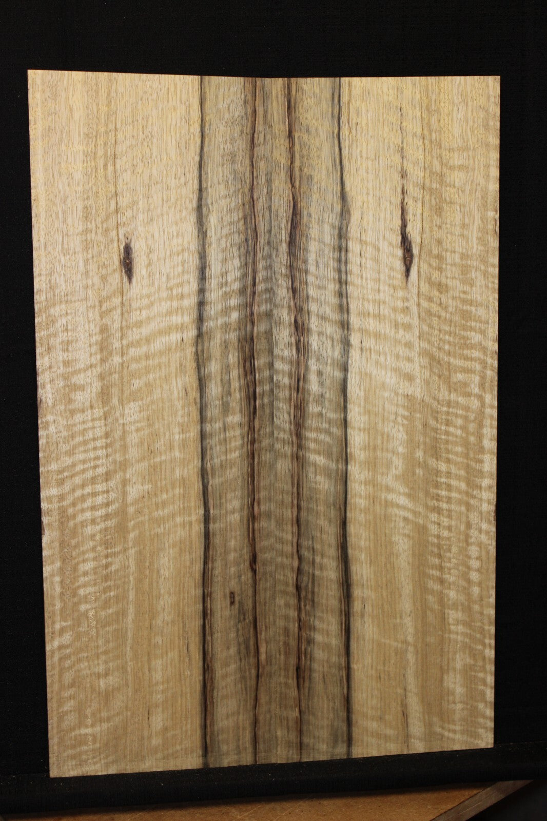 Curly black limba / korina figured book matched guitar top.
