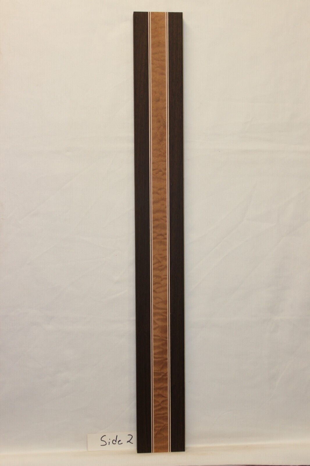 Quilted sapele, wenge, hard maple and purple-heart laminated guitar neck blank.