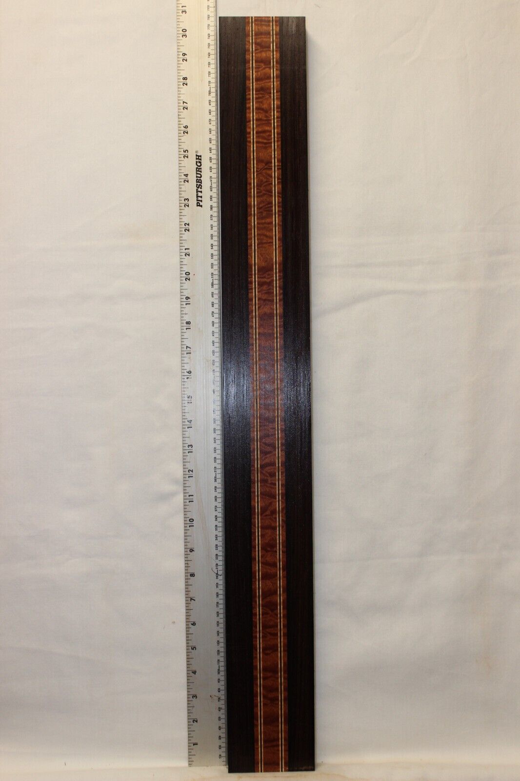 Quilted sapele, wenge and flame maple laminated guitar neck blank.