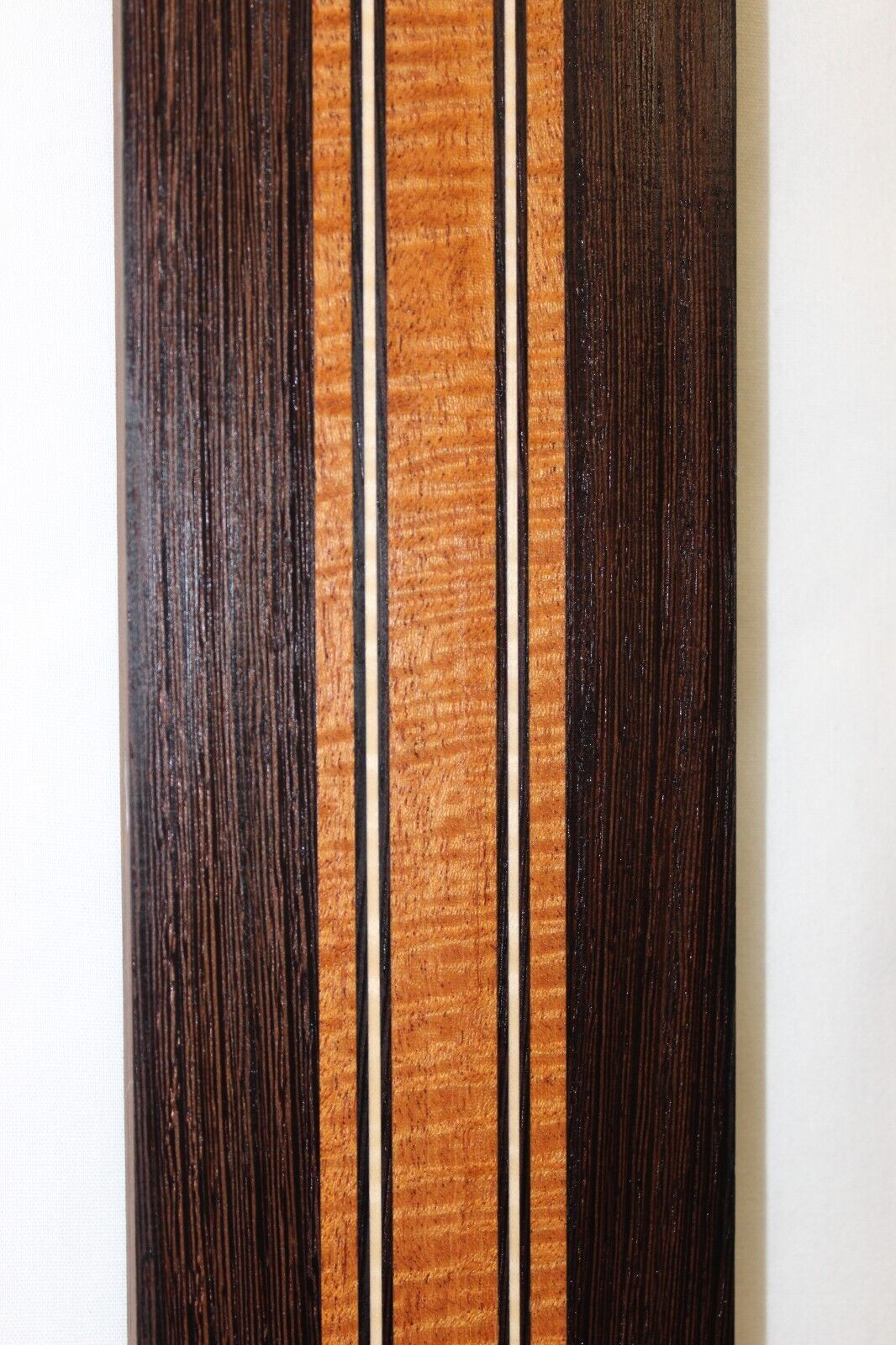 Figured mahogany, wenge and hard maple laminated guitar neck blank.